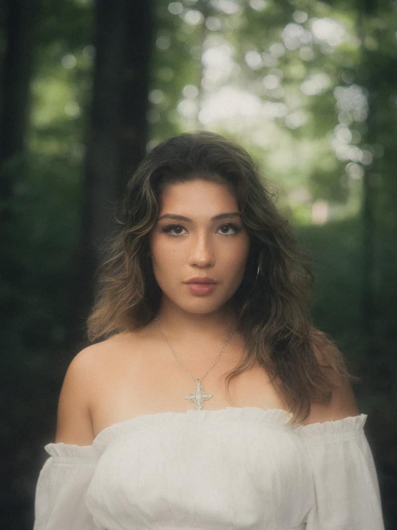 Forest portrait with direct gaze and dewy glow