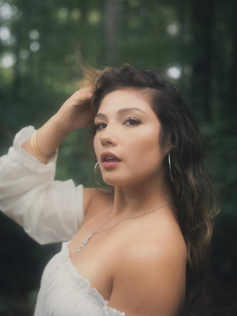 Close-up with hand in hair, forest bokeh
