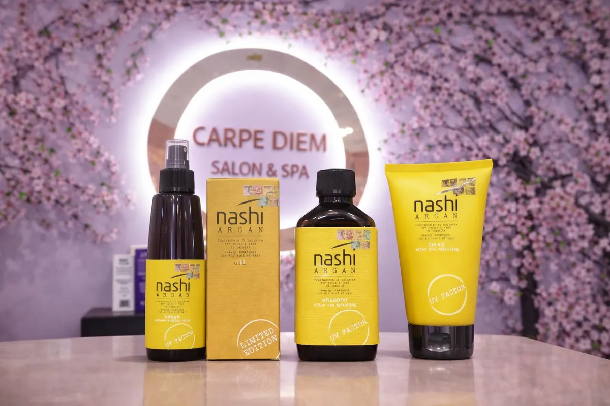 Hair-care products arranged in front of a Carpe Diem Salon and Spa sign · Carpe Diem Salon and Spa