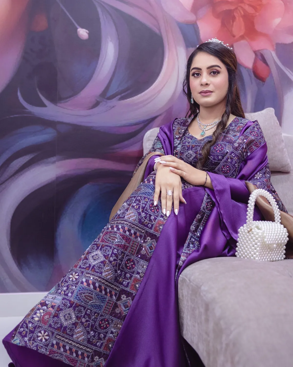 Seated beauty portrait beside a purple salon mural · Carpe Diem Salon and Spa