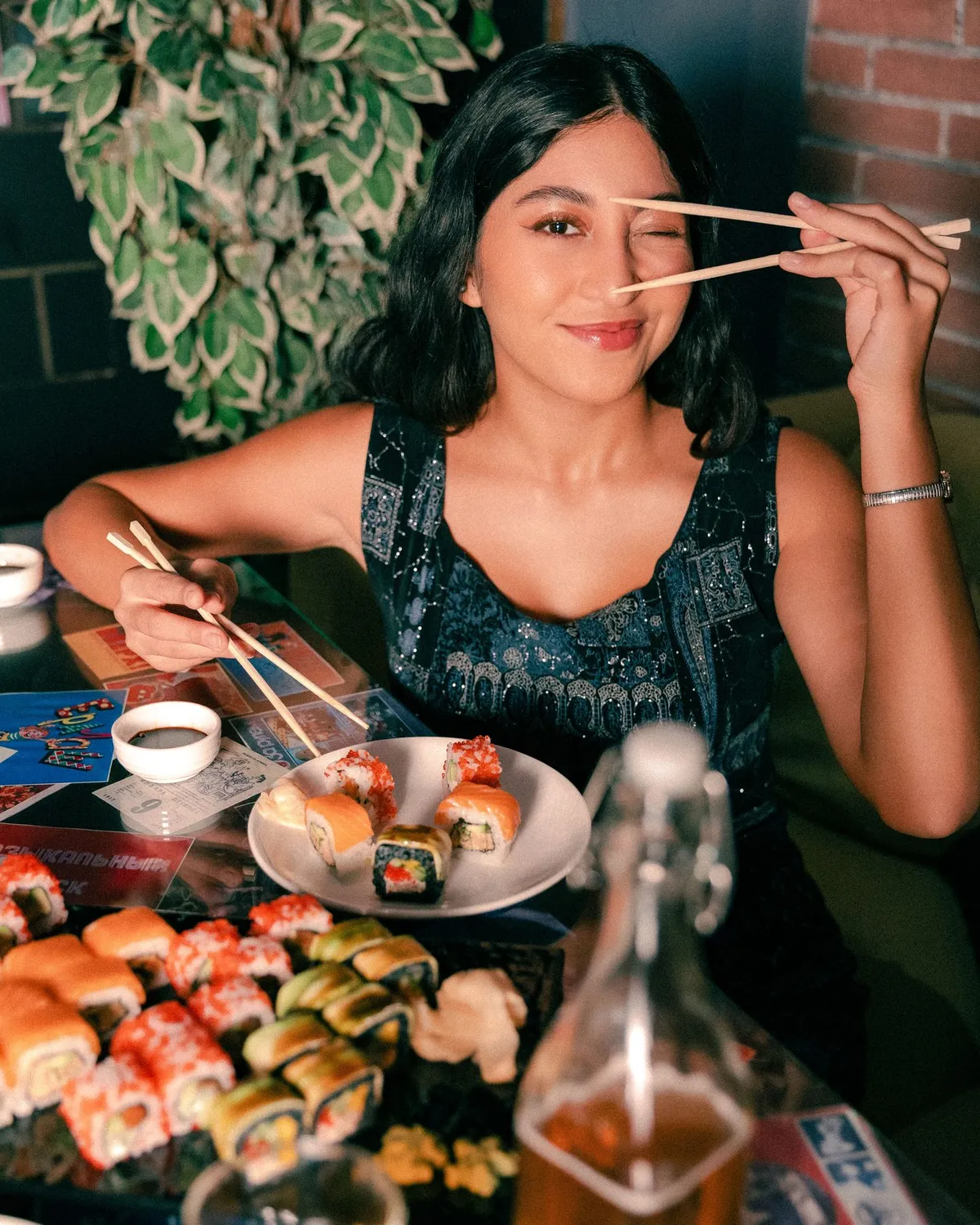 Guest holding chopsticks over a table of sushi · Friends Sushi