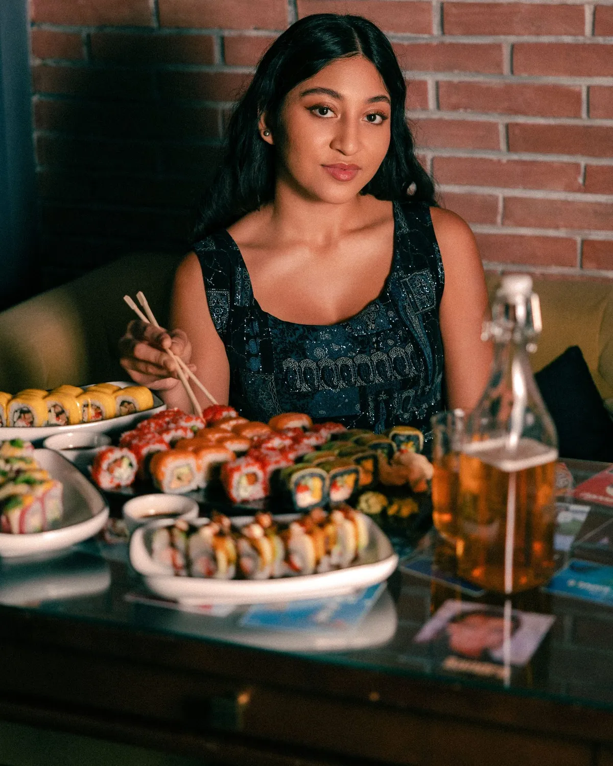 Guest seated at a restaurant table filled with sushi · Friends Sushi