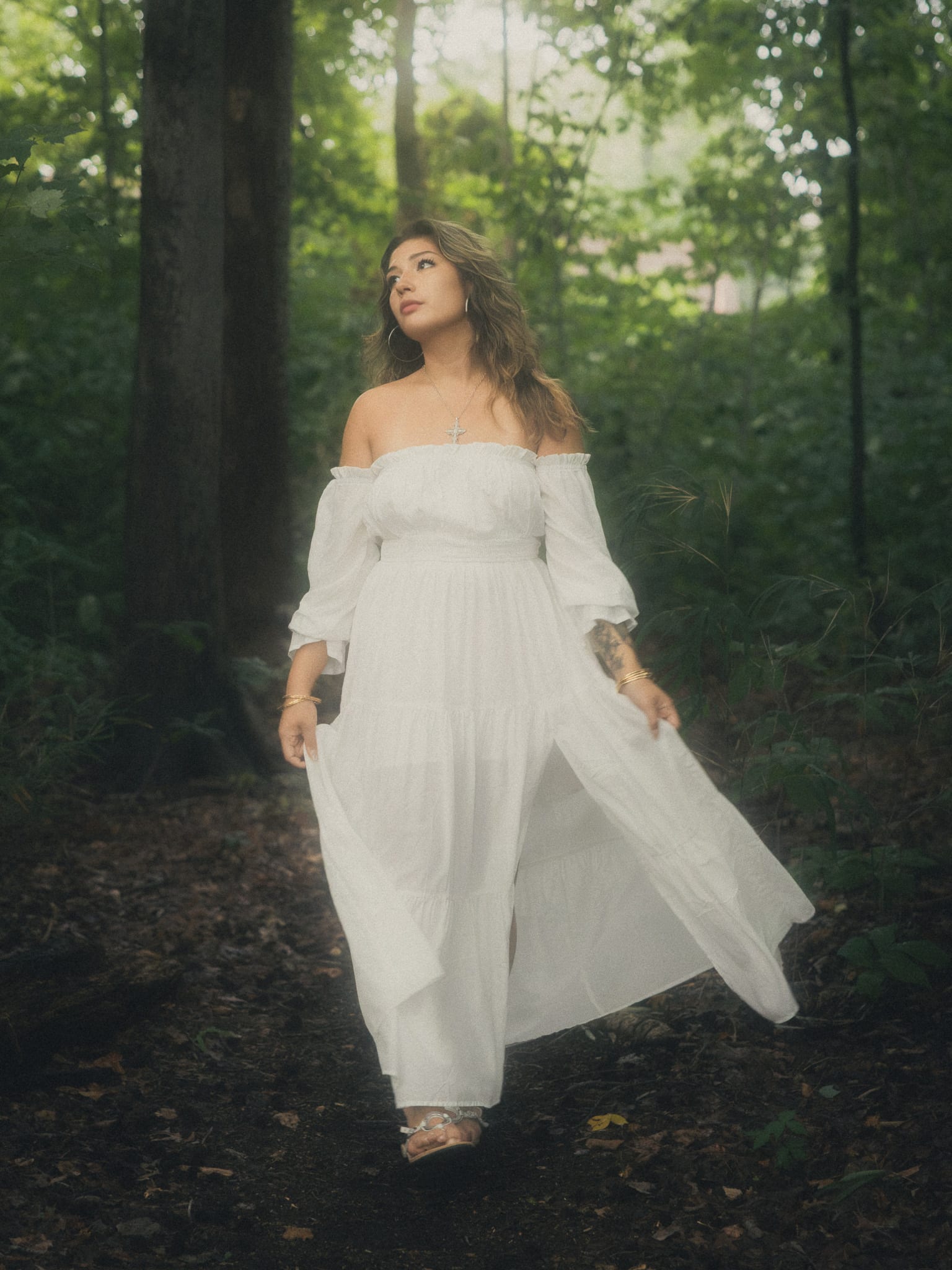 Ethereal walk through dark woods in a luminous dress