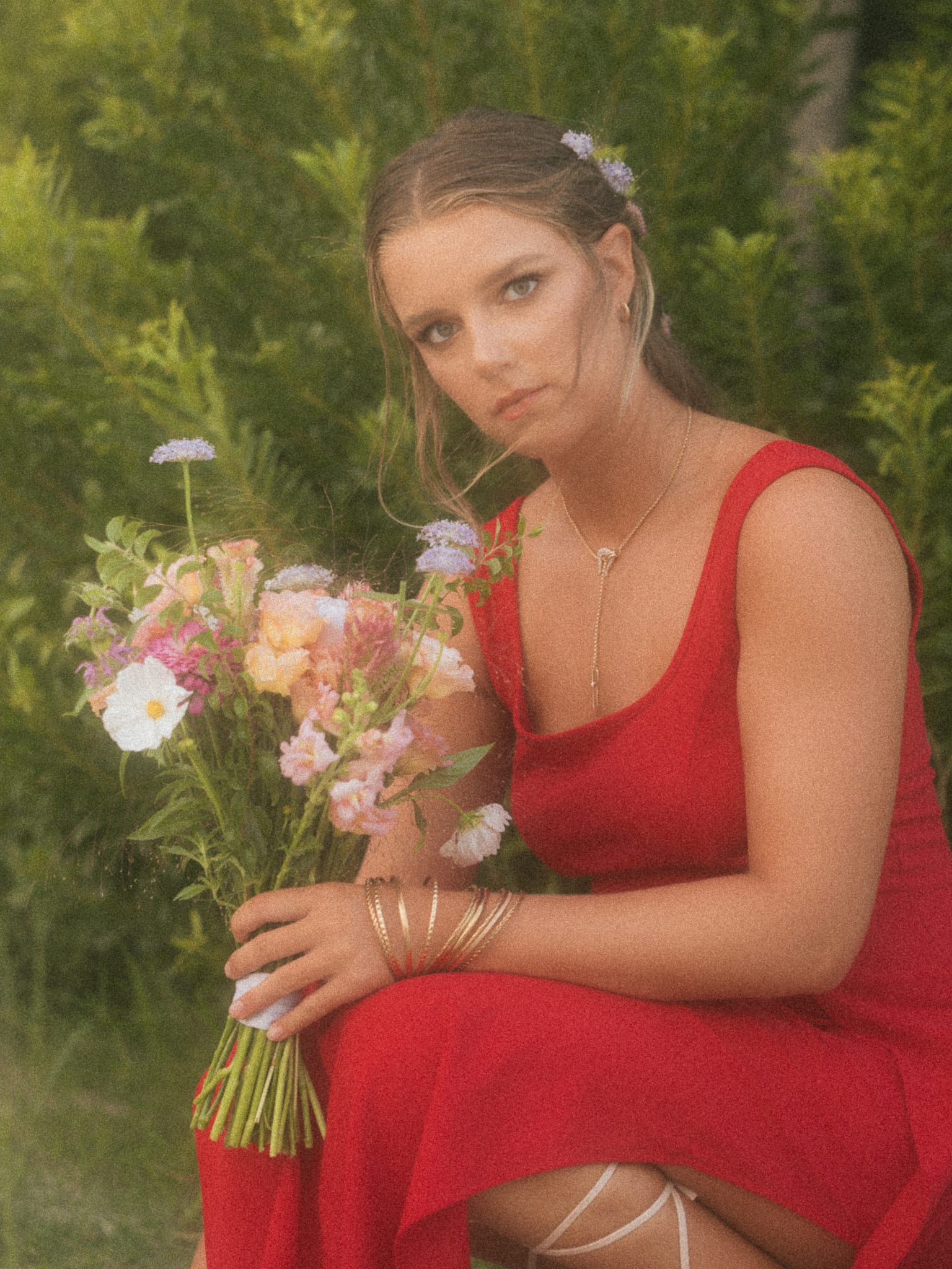 Crouched with a bouquet, level editorial stare